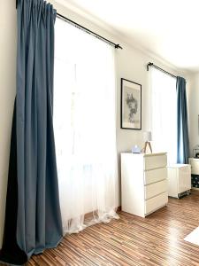 a room with a window with blue curtains and a dresser at Apartmán na Žerotínce in Šumperk +25 photos