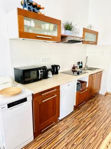 a kitchen with white appliances and a wooden floor at Apartmán na Žerotínce in Šumperk