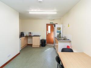 a room with a kitchen with a refrigerator and a table at Tor Hill in Peebles