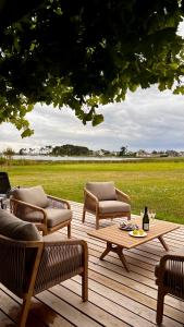 a wooden deck with two chairs and a table at Villa Mamina, face à la mer, île Grande in Pleumeur-Bodou