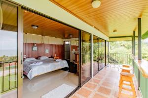 a bedroom in a house with a bed on a balcony at Corcovado Green Cabin & House in Drake