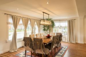 a dining room with a table and chairs and windows at Casablanca in San Martín de los Andes
