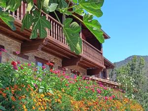 a building with a bunch of flowers in front of it at Apartamentos Calm & Nature - Adults Only in Cabezón de Liébana