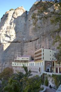 a building sitting in front of a mountain at Guesthouse Chrysa in Kalavrita