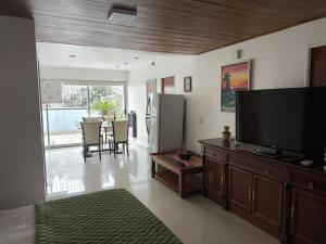 Una sala de estar con un televisor y una mesa con sillas. en Casa Tunez, en Buenos Aires