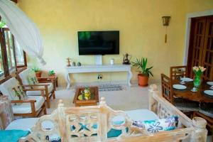 Μια τηλεόραση ή/και κέντρο ψυχαγωγίας στο Tembo Beach Cottage , Ocean Beach Drive
