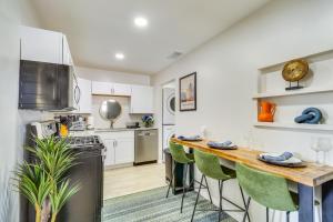 a kitchen with white cabinets and a table with green chairs at Albuquerque Retreat with Hot Tub - Central Location! in Albuquerque