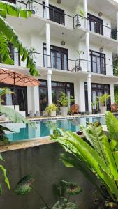 a hotel with a swimming pool in front of a building at The Jini House in Ahangama