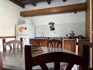 a kitchen with a table and chairs and a refrigerator at Cabañas del Paraiso in Colón