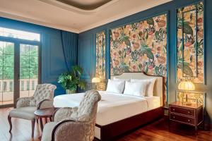 a bedroom with a large bed with blue walls at Boutique Villa 22 - Biệt Thự Trung Tâm Đà Lạt in Da Lat