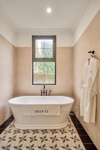 a white tub in a bathroom with a window at Boutique Villa 22 - Biệt Thự Trung Tâm Đà Lạt in Da Lat +63 photos