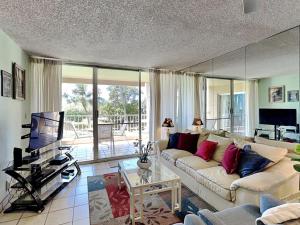 a living room with a white couch and a television at Menehune Shores 206 in Kihei