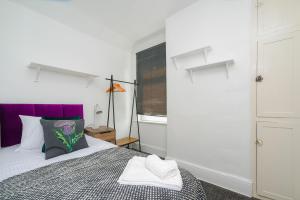a bedroom with a bed with a purple headboard at Feel at Home in Durham, Charming 3-Bedroom Retreat, Sleeps 5, Parking, WiFi in Swindon +12 photos