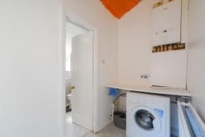 a laundry room with a washing machine and a sink at Feel at Home in Durham, Charming 3-Bedroom Retreat, Sleeps 5, Parking, WiFi in Swindon