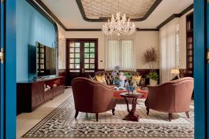 a living room with a couch and chairs and a chandelier at Boutique Villa 22 - Biệt Thự Trung Tâm Đà Lạt in Da Lat