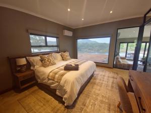 Simbini Sunset Cottage في ماليلين: غرفة نوم بسرير كبير مع نافذة كبيرة