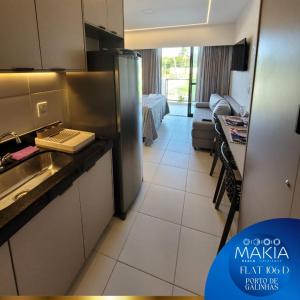 Una cocina con refrigerador de acero inoxidable y una sala de estar. en Flat Makia Beach Experience, en Ipojuca