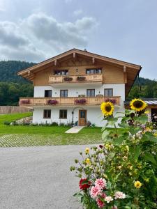 ビショフスヴィーゼンにあるFerienwohnung Hirnsberglehenのバルコニー付きの家、花が目の前に咲いています。