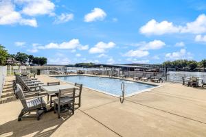 Un patio con mesa y sillas junto a una piscina. en Lakeside Lookout, en Sunrise Beach