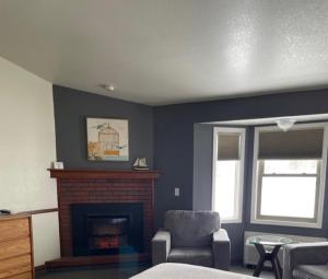 a living room with a fireplace and a chair at Hilltop Inn Broomfield Denver in Broomfield