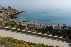 una spiaggia con ombrelloni e persone in acqua di Olivia Budget Apartment a Paralimni Altre 17 foto