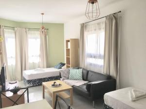 un soggiorno con un divano e un letto di Olivia Budget Apartment a Paralimni