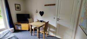 a small table and chairs in a room with a television at Hyggeligt værelse med lækkert badeværelse in Horsens
