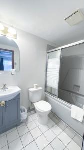 Un baño blanco con inodoro y lavabo. en Commons Inn, en Halifax