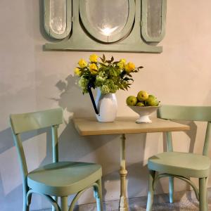 une table avec un vase de fleurs et deux chaises dans l'établissement Amaretto, à Tivoli 6 autres photos