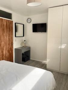a bedroom with a white bed and a clock on the wall at Fabulous 1Bed Apt with Balcony in Central Birmingham in Birmingham