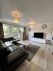 a living room with a black couch and a tv at Fabulous 1Bed Apt with Balcony in Central Birmingham in Birmingham