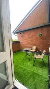 a patio with a table and chairs on the grass at Fabulous 1Bed Apt with Balcony in Central Birmingham in Birmingham
