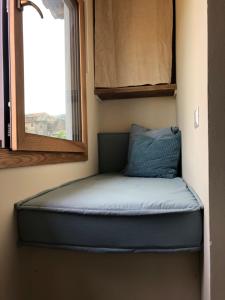 un petit lit dans une petite maison avec une fenêtre dans l'établissement Amaretto, à Tivoli