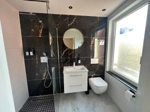 ein Badezimmer mit Toilette und Spiegel in der Unterkunft Charmante Ferienwohnung mit großer Dachterrasse & Wintergarten in Gau-Algesheim + 14 Fotos