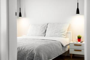 una camera bianca con letto bianco e comodino di Apartament Stacja Wisła a Wisła