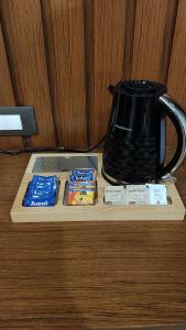 a table with a coffee pot and packets of tea at The Caligo resort coorg in Madikeri