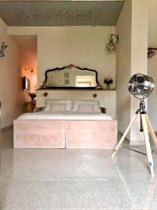 - une chambre avec un lit avec un miroir et un ventilateur dans l'établissement Amaretto, à Tivoli