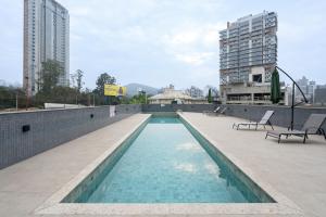 a swimming pool on the roof of a building at Localização Central! A 450 metros da Vila Germânica Loft com Piscina, Ar-Condicionado, Wi-Fi, Cozinha completa, Garagem Privativa, Espaço Zen, Academia, Sauna, e Mercadinho 24h in Blumenau