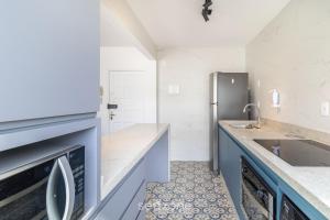 uma cozinha com pia e geladeira em Apartamento Aconchegante Bem Localizado RBE0031 em Florianópolis