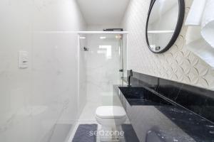 um banheiro branco com um vaso sanitário e um espelho em Apartamento Aconchegante Bem Localizado RBE0031 em Florianópolis mais 11 fotografias