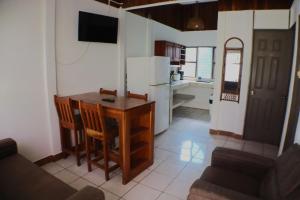 a living room with a table and a kitchen at Coconut Beach House in Playa Conchal