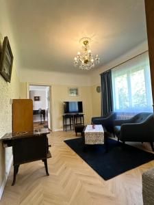ein Wohnzimmer mit einer Couch und einem Klavier in der Unterkunft Strawberry Forest in Jūrmala