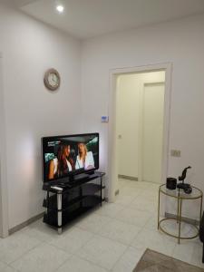 ein Flachbildfernseher, der auf einem Ständer in einem Zimmer steht in der Unterkunft Mazzini Apartment - THE V Collection in Turate