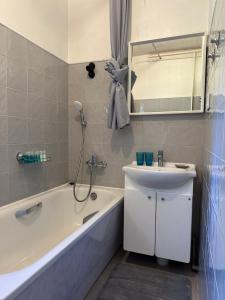 ein Badezimmer mit Badewanne und Waschbecken in der Unterkunft Strawberry Forest in Jūrmala + 30 Fotos