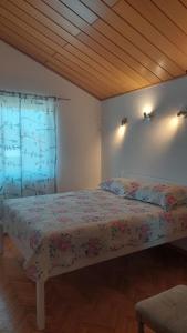 een slaapkamer met een bed met een bloemenbed bij Apartments Lucija-Klara in Brodarica +31 foto's
