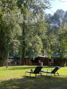 a person laying in a hammock between two chairs in a park at Drinka in Ljubovija