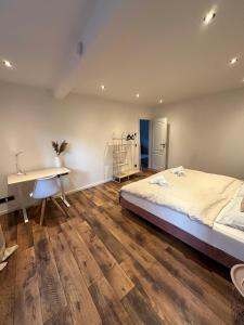 ein Schlafzimmer mit einem Bett, einem Schreibtisch und einem Tisch in der Unterkunft Charmante Ferienwohnung mit großer Dachterrasse & Wintergarten in Gau-Algesheim