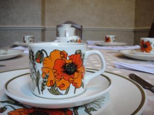eine Kaffeetasse auf einem Teller auf einem Tisch in der Unterkunft Bankside Bed & Breakfast in St Austell