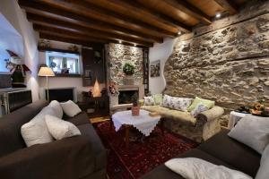 a living room with couches and a stone wall at La Villa De Rosses- Sana Halkidiki in Saná