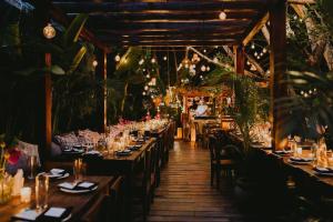 a restaurant with long tables and chairs and lights at 3BR Penthouse with Rooftop Pool Near Centro in Tulum +82 photos